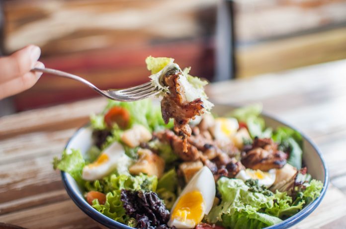 A high-angle close-up view of a salad in a bowl Sabor y Cuidado: Guarniciones y porciones a la medida